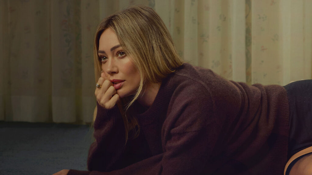 Singer Hilary Duff posing promiscuously in a dark room.