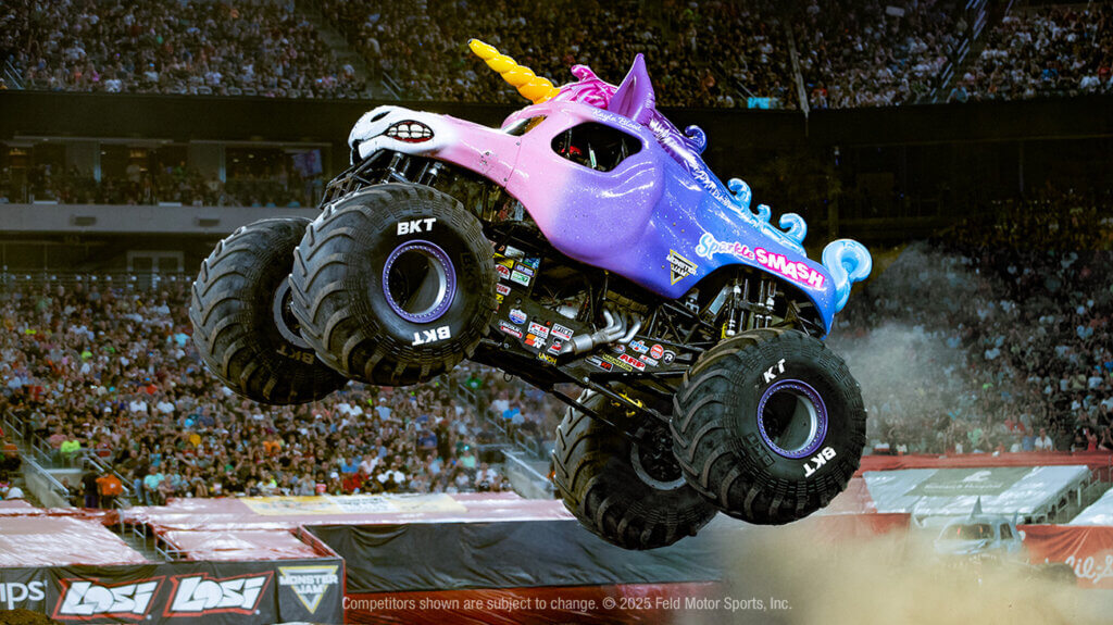 Monster truck performing a jump in an arena.