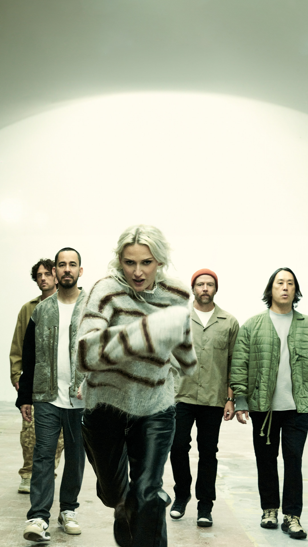 Linkin Park band members gathered in a room, standing together and interacting with one another.