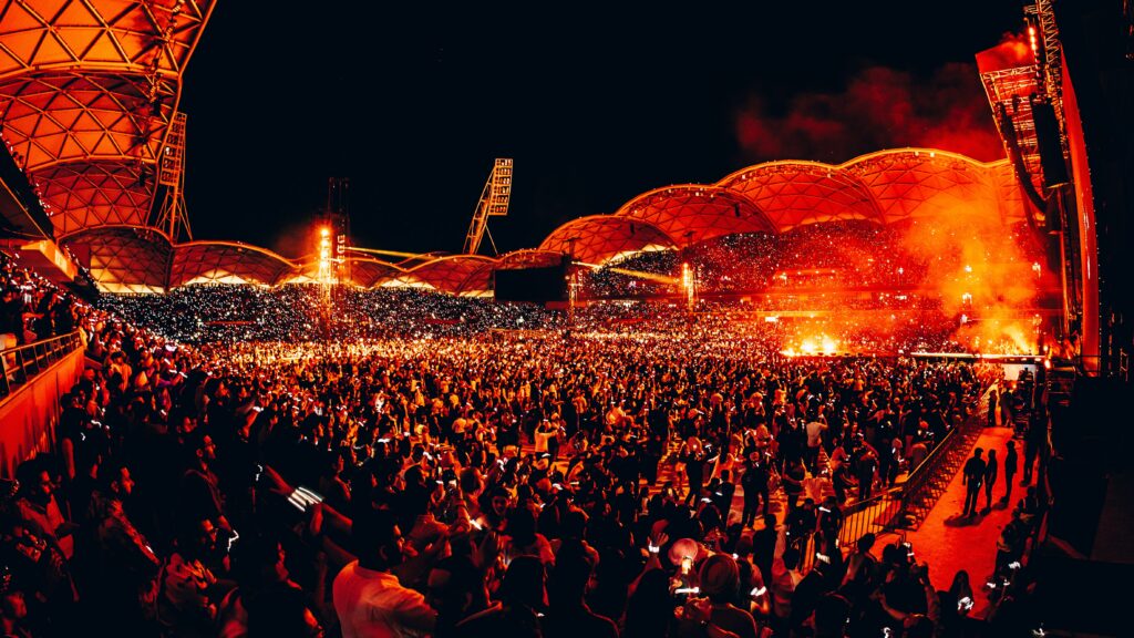 Concert being held at AAMI Park with bright red lighting.